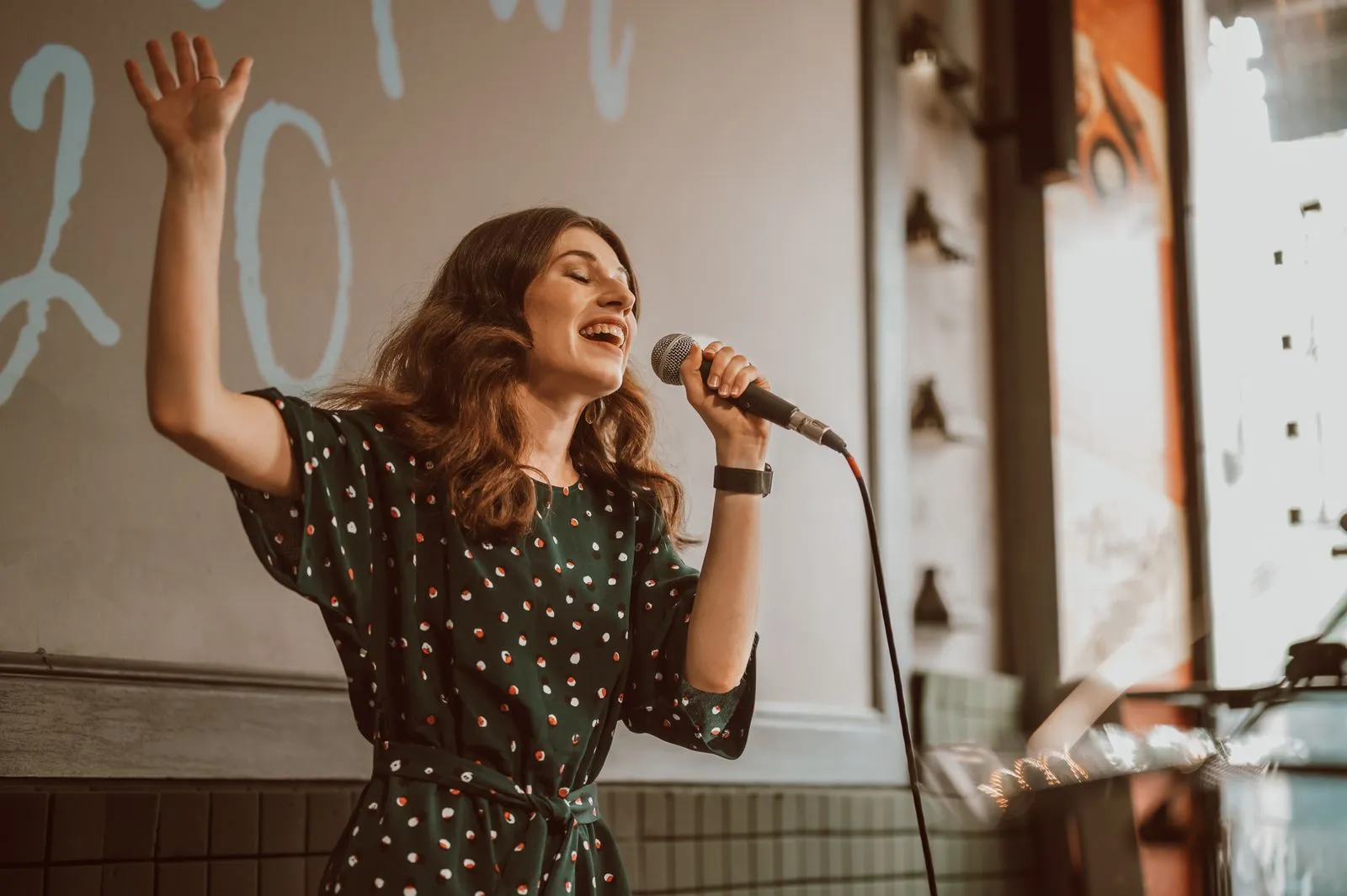 Female musician singing passionately with a microphone indoors.